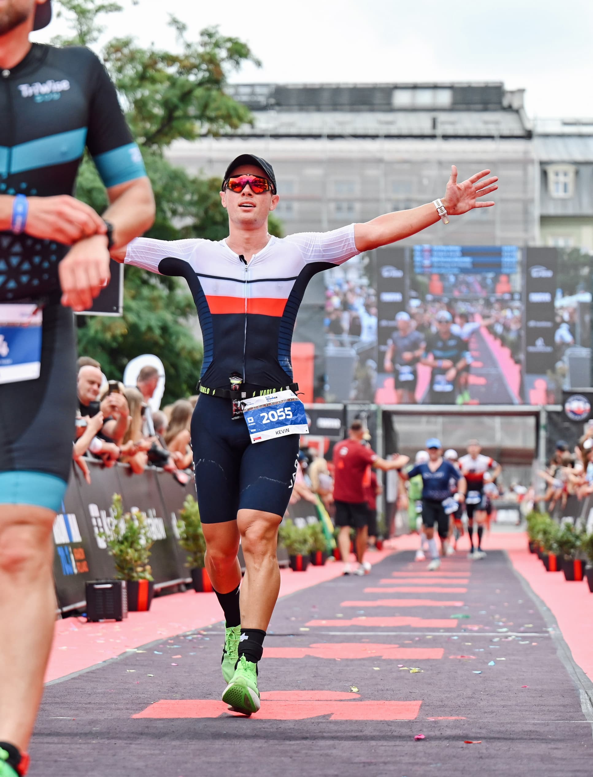 Kevin Ostajewski crossing an Ironman finish line